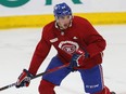 Close-up of Canadiens prospect Logan Mailloux wearing a red jersey with his stick in his hand on the ice in Brossard.