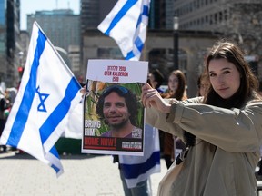 A woman holds up a photo during a vigil by students at McGill