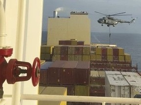 This image made from a video provided to The Associated Press by a Mideast defense official shows a helicopter raid targeting a vessel near the Strait of Hormuz on Saturday, April 13, 2024.