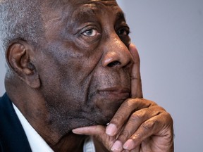 Dan Philip, a black man, is seen from the side, chin resting in his hand.