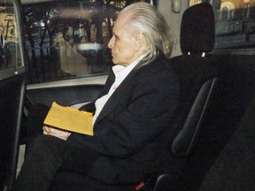 Peter Nygard is seen through a police vehicle window in Toronto on Oct. 3, 2023.