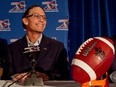 Marc Trestman smiles while sitting at a table during a news conference