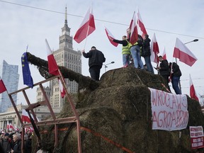 Polish farmers with national flags and angry slogans written on boards protest against European Union green policies.