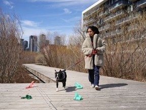 Local resident Cemre Uzumnehmetoglu and her dog Viktor walk on the boardwalk of Montreal's Lachine Canal in Montreal, Wednesday, April 17, 2024. Parks Canada has removed trash cans from sections of Montreal's Lachine Canal leading to bags of waste and litter being dropped throughout the site.