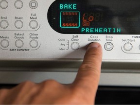 A control panel for a cooking appliance. A finger is pressing the Cook Duration button.