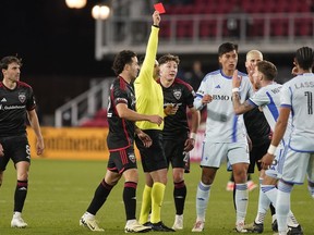 Referee Ramy Touchan issues a red card to CF Montreal centre back Joel Waterman, which was later overturned on review, during the second half of the team's MLS soccer match against D.C. United, Saturday, March 30, 2024, in Washington. Major League Soccer fined CF Montreal defender Joel Waterman an undisclosed amount Tuesday for failing to leave the field in a timely manner in last Saturday's match against D.C. United.