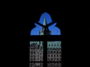 The Confederation Building is pictured through a window of West Block on Parliament Hill in Ottawa on Tuesday, April 16, 2024.