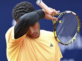 Félix Auger Aliassime wipes his face during the men's singles quarterfinal match against Germany's Jan-Lennard Struff at the ATP Tour in Munich, Germany, Saturday April 20, 2024.