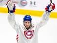 Chris Wideman puts his arms in the air to celebrate while wearing a Canadiens white practice jersey on the ice