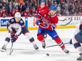 Canadiens' Alex Newhook skates between Blue Jackets' Alexandre Texier, left, and Erik Gudbranson during a game this year.