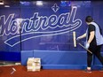 A woman cleans glass in front of a wall with Montreal written on it
