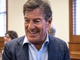 Stephen Bronfman smiles while wearing a shirt and jacket