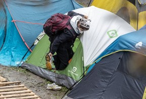 A pro-Palestinian demonstrator removes her shoes before entering her tent in the encampment on the campus of McGill University in Montreal on Thursday, May 2, 2024.
