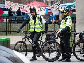 Montreal police stand outside the McGill campus on Wednesda,y May 1, 2024 after a judge rejected an injunction request seeking to have the pro-Palestinian encampment dismantled.