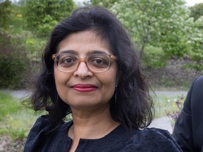 Dr. Kaberi Dasgupta is seen in a close-up otside, wearing her glasses and smiling with her lips closed for the camera.