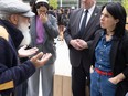 Valérie Plante, hands in her pockets, listens to an elderly man speaking while gesturing