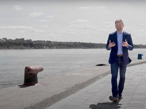 A man walks along the water, talking