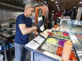 Irfan Inoglu is at a counter with all the fixings in front of him as he prepares a sandwich at Berlin Doner in the location of the former Main Deli on St-Laurent Blvd.
