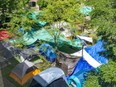 Overview of a tent encampment through the trees.