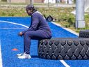 Injured reciever Reggie White Jr. sits on a tire on the sidelines during Alouettes training camp in Trois-Rivières last year.