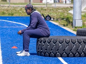 Injured reciever Reggie White Jr. sits on a tire on the sidelines during Alouettes training camp in Trois-Rivières last year.