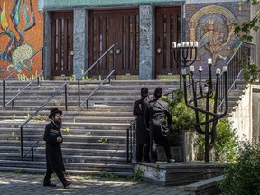 Orthodox Jews walk past a synagogue