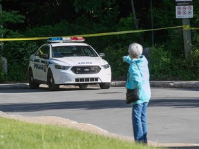 A woman points at a police car.