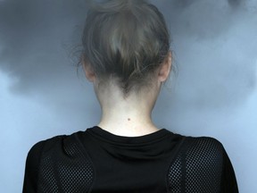 A girl seen from the back with a dark cloud on her head.