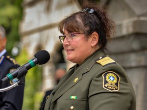 Johanne Beausoleil at a podium microphone outside in an SQ uniform