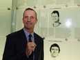 Guy Carbonneau, seen in a dark jacket, striped blue and white shirt and dark tie, shows off his Hall of Fame ring in front of his plaque at the Hockey Hall of Fame in Toronto in 2019.