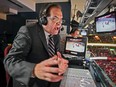 RDS hockey play-by-play announcer Pierre Houde has headphones on and is surrounded by monitors in the broadcast booth at the Bell Centre.