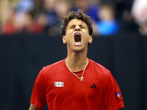 A tennis player screams after winning a set