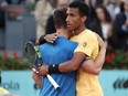 Félix Auger-Aliassime hugs another player on the tennis court