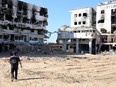 A rescuer walks toward buildings devastated by Israeli strikes at the Al-Shifa medical complex in Gaza City on May 8, 2024.