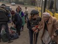 Evacuees arrive by bus at an evacuation point in the Kharkiv region, on May 12, 2024, amid the Russian invasion of Ukraine.