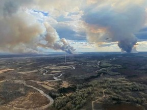 This handout image released by Alberta Wildfire shows smoke columns going in multiple directions due to shifting winds in Fort McMurray Forest Area, Alta., on May 13, 2024.
