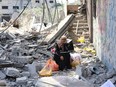 A woman sits amid the debris of a building destroyed by Israeli bombardment in the al-Zaitoun neighbourhood of Gaza City in the northern part of the Palestinian territory on May 15, 2024, as the conflict between Israel and the militant Hamas movement continues.