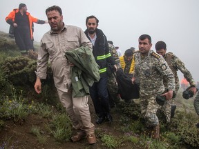 Rescue team members recover the body of a victim from the crash site of a helicopter carrying Iranian President Ebrahim Raisi in Varzaghan, in northwestern Iran, on May 20, 2024.