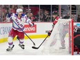 Rangers' Chris Kreider is seen behind the Hurricanes' net, pointing to the puck in the net as former Canadien Jesperi Kotkaniemi trails the play.