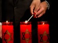 Participants light one of six candles during a Holocaust commemorative ceremony to mark Yom HaShoah