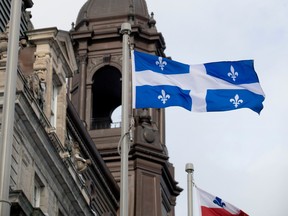 A Quebec flag flying beside a building.
