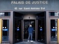 A person walks through revolving doors. A sign above the door says Palais de justice