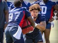 Defensive lineman Mustafa Johnson, right, pushes past T.D. Moultry during Alouettes training camp practice in St-Jérôme last week.