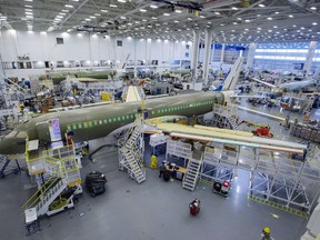 A plane is seen under construction in a hangar.
