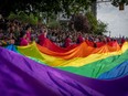 A large pride flag is passed along during the Pride Parade at English Bay in Vancouver, Sunday, Aug. 6, 2023.