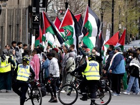 Police watch a pro-Palestinian protest with many waving flags