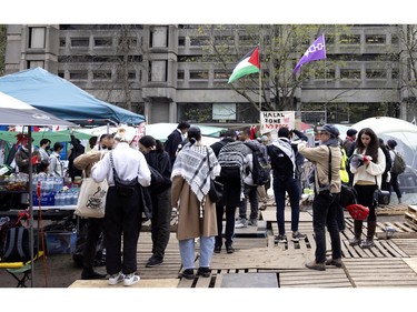 People arrive to donate food and water at a community food and water station in the pro-Palestinian encampment on McGill's lower field in Montreal on Saturday, May 4, 2024.