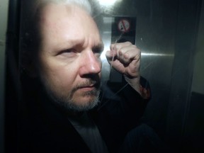 WikiLeaks founder Julian Assange is led out of the London court on Wednesday, May 1, 2019, where he appeared seven years ago on charges of skipping British bail.