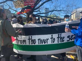 Protesters hold up a sign at a pro-Palestinian encampment set up on the University of Toronto campus on Thursday, May 2, 2024.