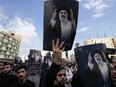 People hold up posters of Iranian President Ebrahim Raisi during a mourning ceremony for him at Vali-e-Asr square in Tehran, Iran, Monday, May 20, 2024.